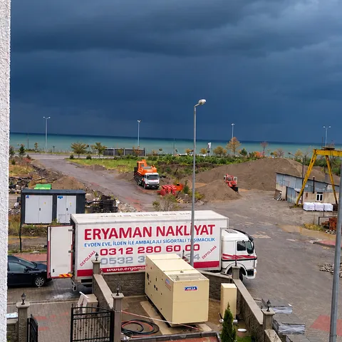 Deniz kıyısındaki binaların önünde park edilmiş Eryaman Nakliyat kamyonu